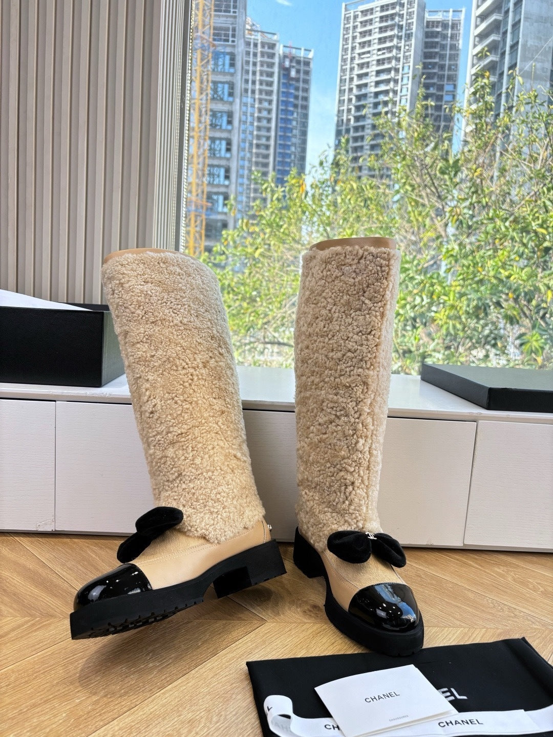 KNEE-HIGH SHEARLING BOOTS WITH PATENT CAP TOE AND BOW DETAIL