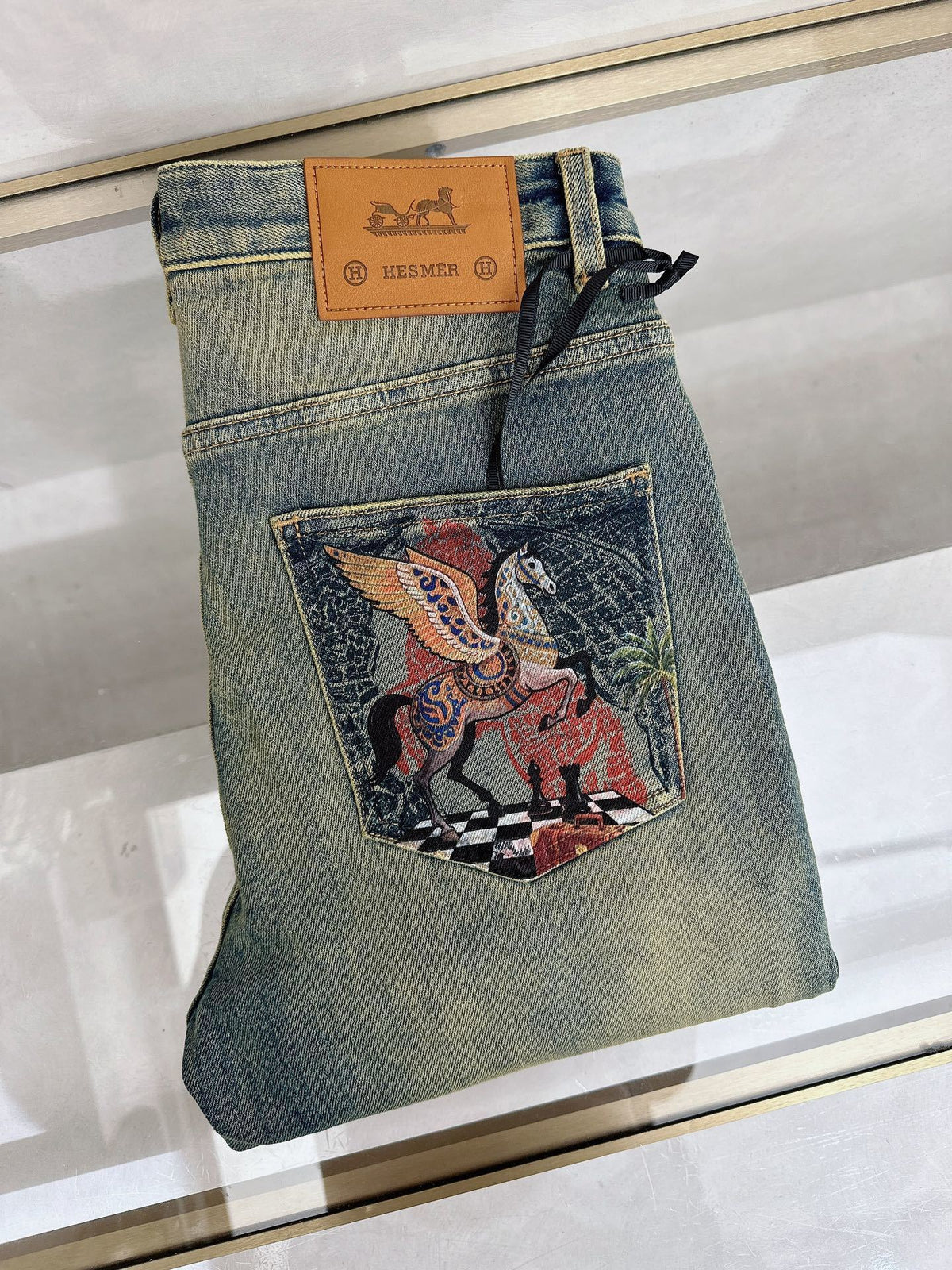 DISTRESSED DENIM JEANS WITH GRAPHIC BACK POCKET